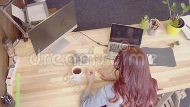 女商人在她的工作场所做纸笔，喝茶。